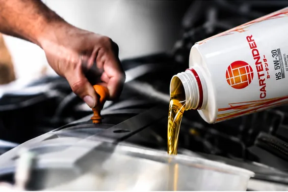 Cartender engine oil being poured into a car engine
